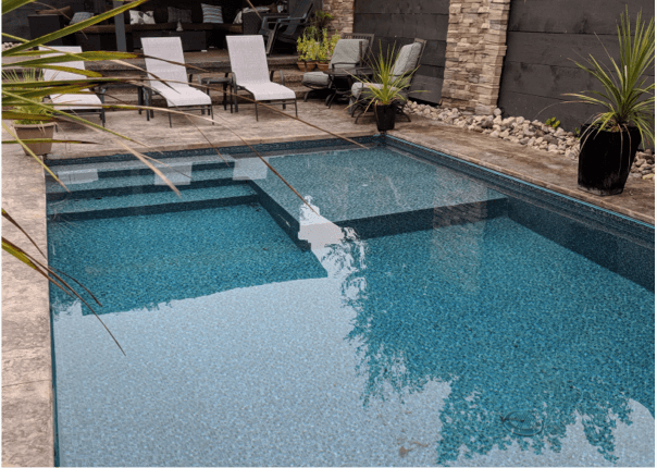 inground swimming pool with tanning ledge and spa